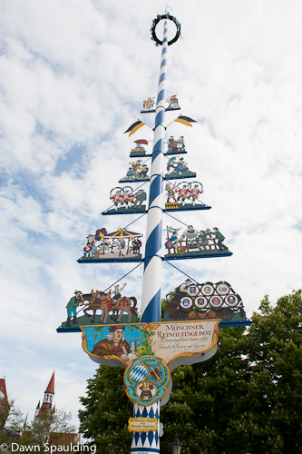 Viktualienmarkt maypole displays artisan symbols and traditional white-and-blue Bavarian stripes